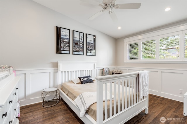 bedroom with a decorative wall, dark wood finished floors, a wainscoted wall, recessed lighting, and a ceiling fan