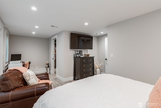 bedroom featuring light wood finished floors, recessed lighting, and baseboards