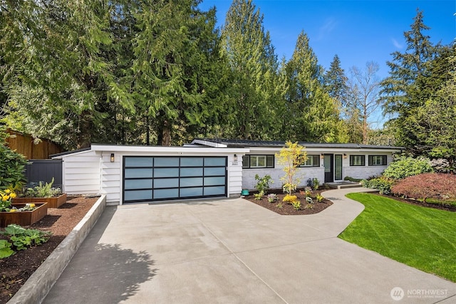 view of front of property with driveway, a garage, and a vegetable garden