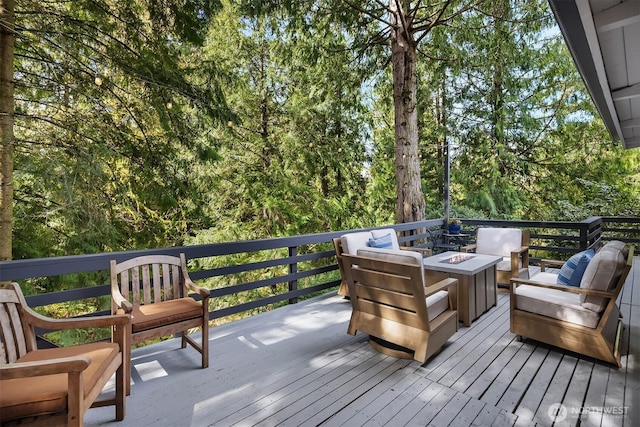deck with an outdoor living space with a fire pit