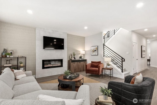 living room featuring recessed lighting, wood finished floors, and stairs