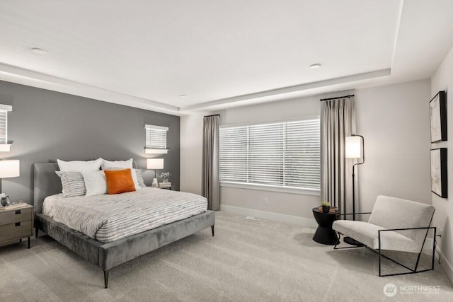 bedroom with carpet flooring, baseboards, and a tray ceiling