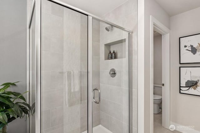 full bathroom featuring toilet and a shower stall