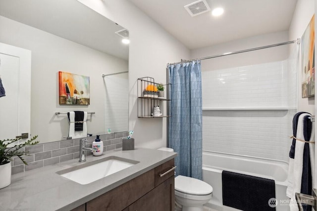 full bath featuring toilet, shower / bath combo with shower curtain, vanity, and visible vents