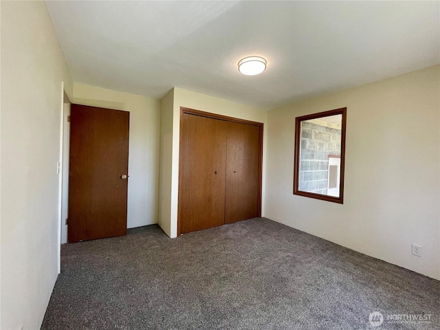 unfurnished bedroom featuring carpet and a closet