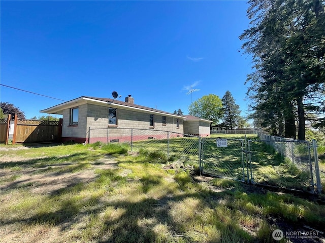 back of property with fence, a gate, and a chimney