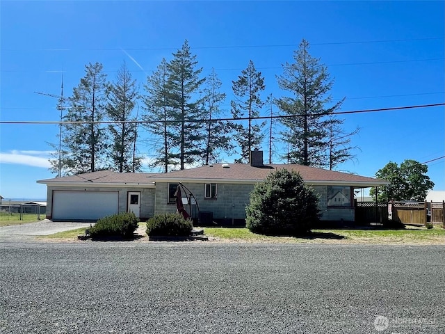 single story home featuring a chimney, fence, a garage, and concrete driveway