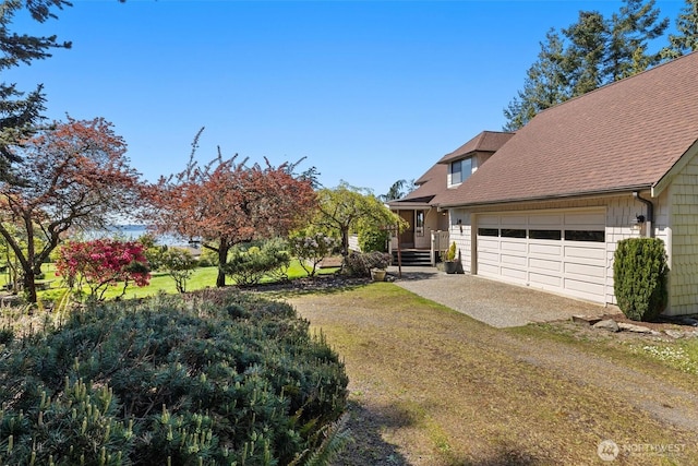 565 Olympic View Ln, Camano Island, WA 98282 - view of grassy yard with an attached garage and dirt driveway