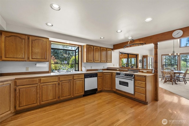 565 Olympic View Ln, Camano Island, WA 98282 - kitchen with dishwashing machine, white electric stove, recessed lighting, ornate columns, and brown cabinetry