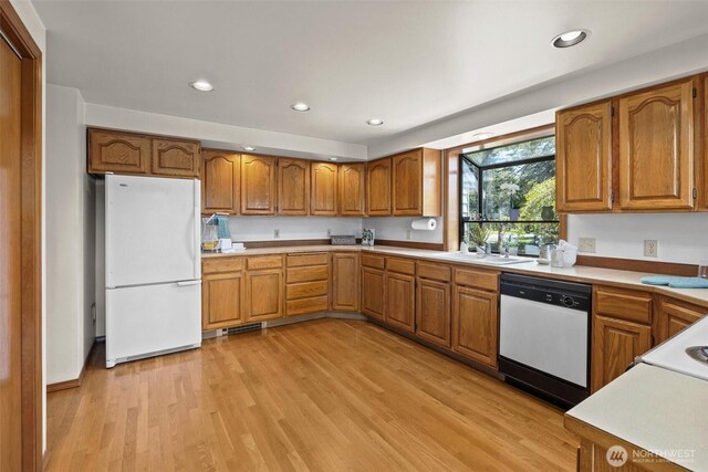 565 Olympic View Ln, Camano Island, WA 98282 - kitchen featuring white appliances, brown cabinetry, light wood-style floors, light countertops, and recessed lighting