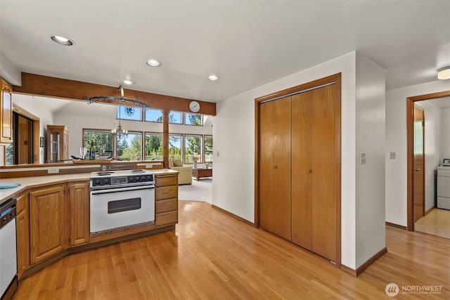 565 Olympic View Ln, Camano Island, WA 98282 - kitchen with white appliances, recessed lighting, light wood-type flooring, brown cabinetry, and washer / clothes dryer