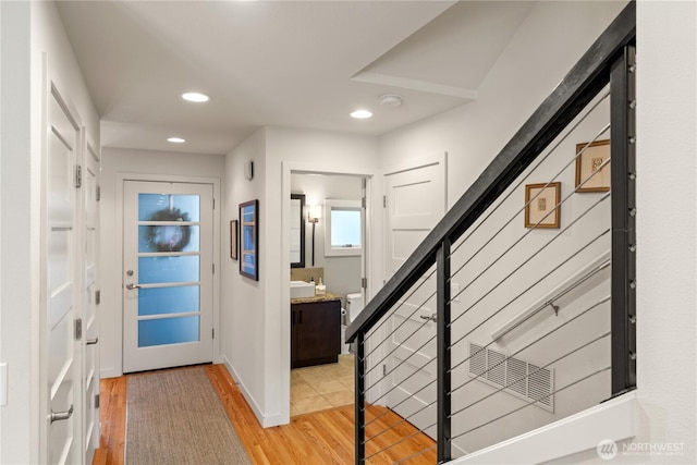 entrance foyer with light wood finished floors and recessed lighting