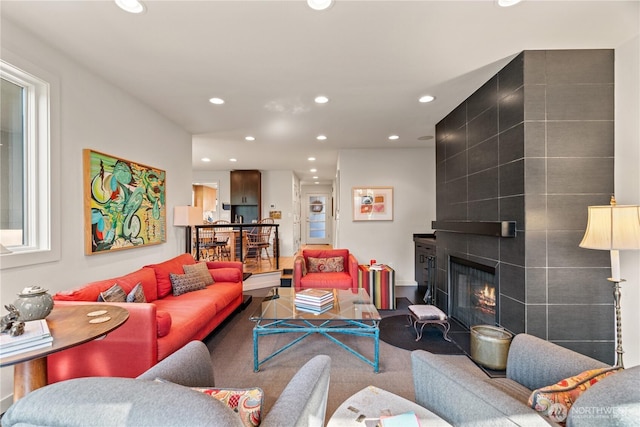 living area with a tile fireplace and recessed lighting