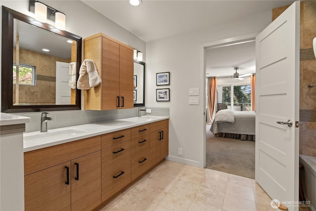 ensuite bathroom with a sink, double vanity, ensuite bath, and tile patterned flooring