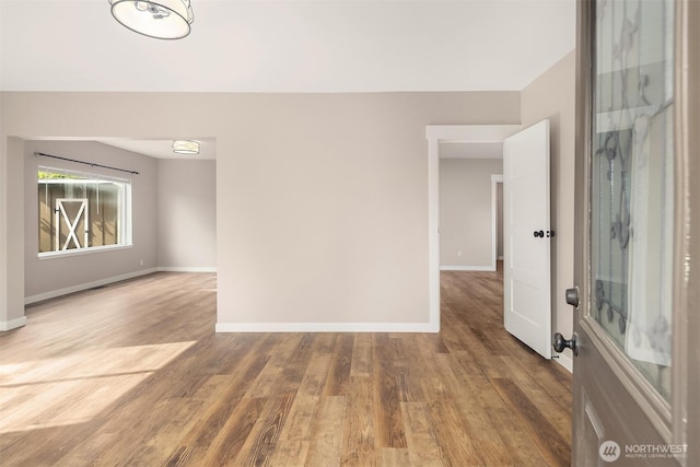 empty room featuring baseboards and wood finished floors