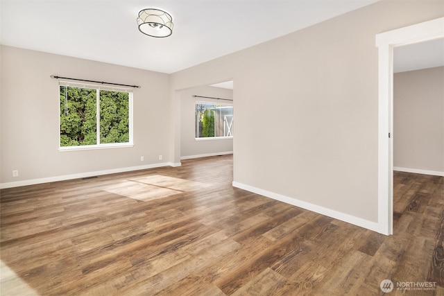 empty room featuring wood finished floors and baseboards