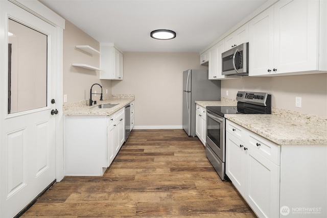 kitchen featuring stainless steel appliances, a sink, white cabinets, dark wood-type flooring, and open shelves