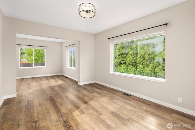 unfurnished room with baseboards and wood finished floors