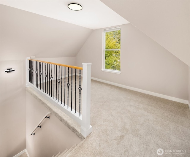 additional living space with carpet floors, vaulted ceiling, and baseboards
