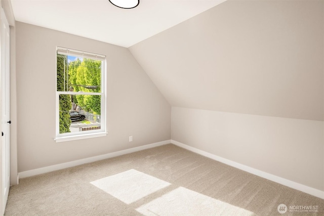 additional living space with carpet floors, baseboards, and lofted ceiling