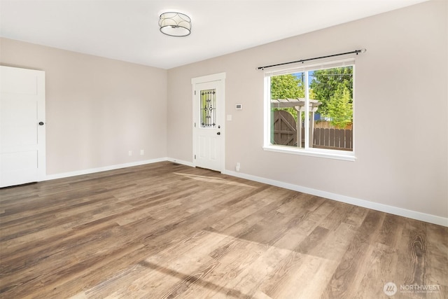 unfurnished room with wood finished floors and baseboards