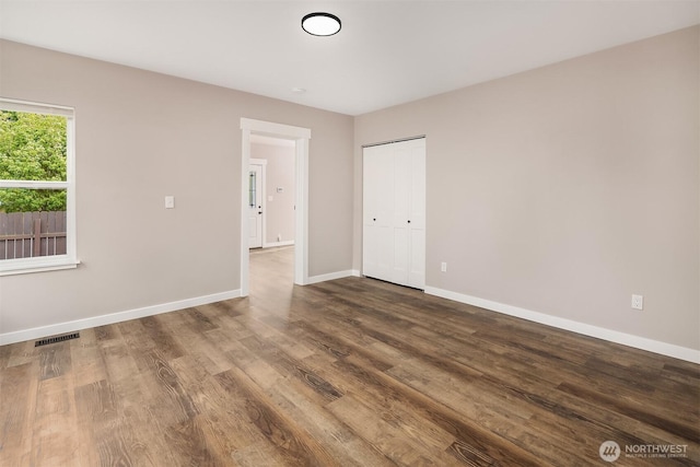 unfurnished room featuring baseboards and wood finished floors