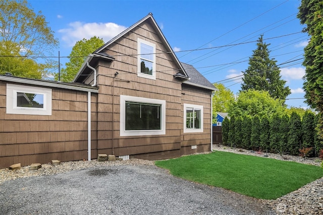 view of side of property featuring a lawn and crawl space