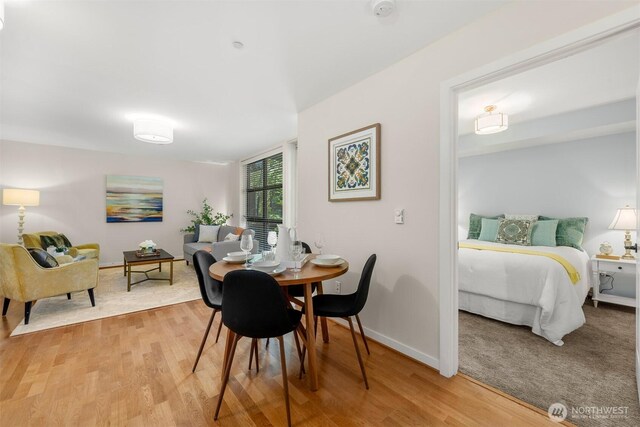 dining space featuring light wood-style flooring and baseboards