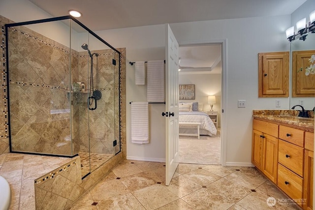 ensuite bathroom with a stall shower, baseboards, vanity, and recessed lighting