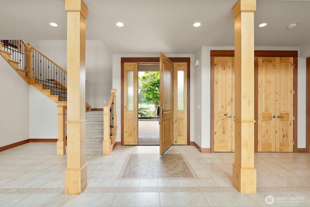foyer entrance featuring ornate columns, baseboards, tile patterned flooring, stairs, and recessed lighting