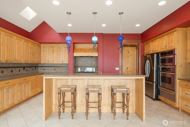 kitchen with a warming drawer, backsplash, stainless steel appliances, a kitchen island, and recessed lighting
