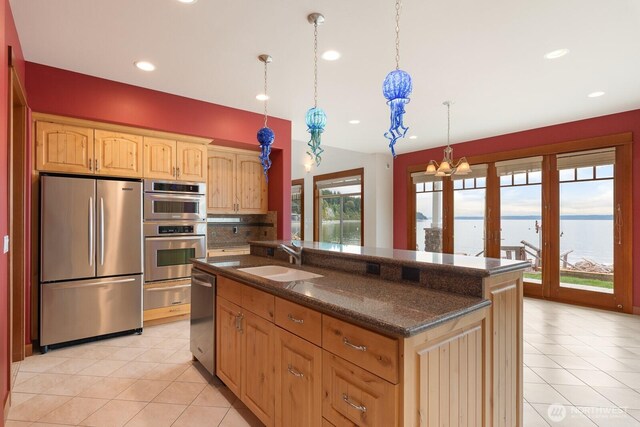 kitchen featuring appliances with stainless steel finishes, a sink, a chandelier, light tile patterned floors, and recessed lighting