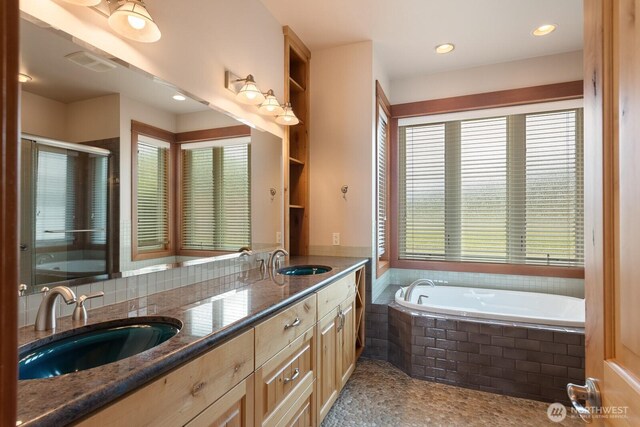 full bathroom featuring a garden tub, double vanity, and a shower stall