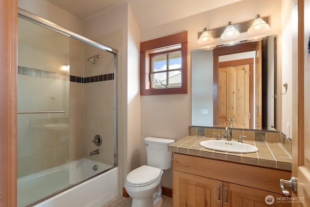 full bath featuring toilet, vanity, and bath / shower combo with glass door
