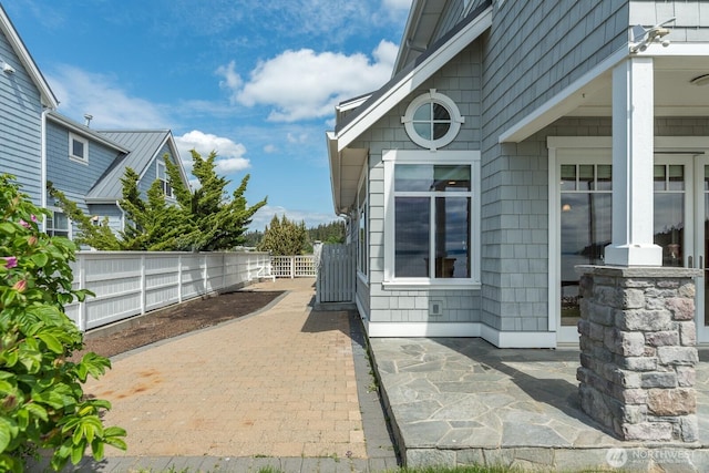 view of side of home with fence and a patio area