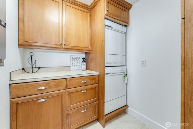 2015 SE Columbia River Dr Unit 320, Vancouver, WA 98661 - kitchen featuring stacked washer / dryer, oven, brown cabinetry, baseboards, and light countertops