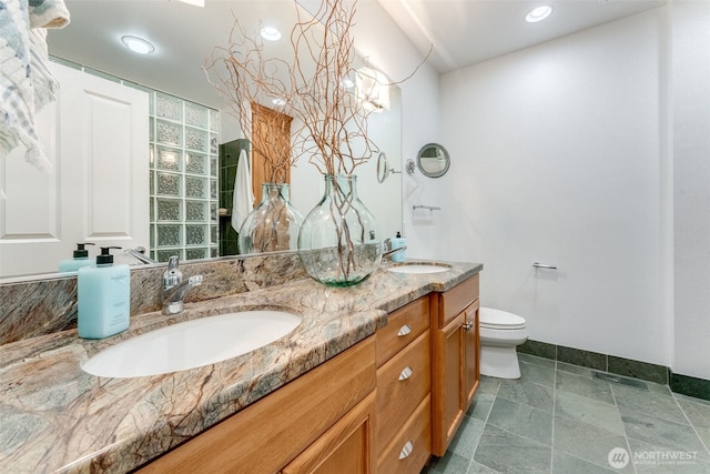 2015 SE Columbia River Dr Unit 320, Vancouver, WA 98661 - bathroom with toilet, baseboards, double vanity, and a sink