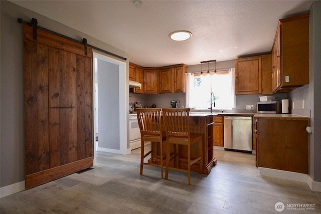 20005 Carper Rd SW, Rochester, WA 98579 - kitchen with dishwasher, brown cabinetry, a center island, and a sink