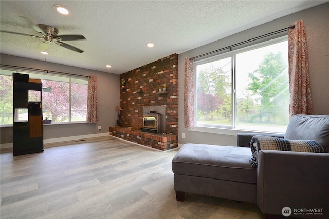 20005 Carper Rd SW, Rochester, WA 98579 - living area featuring wood finished floors, a wood stove, ceiling fan, recessed lighting, and a textured ceiling