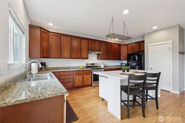 27859 256th Ct SE, Maple Valley, WA 98038 - kitchen featuring stainless steel gas range, black fridge with ice dispenser, a sink, recessed lighting, and a kitchen bar