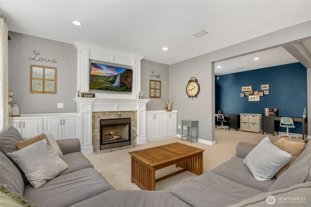 carpeted living area with recessed lighting, a fireplace, and a desk