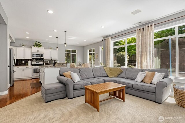 living area with recessed lighting and wood finished floors
