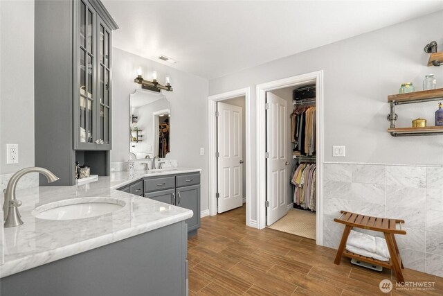 bathroom with vanity, a spacious closet, and wood finished floors