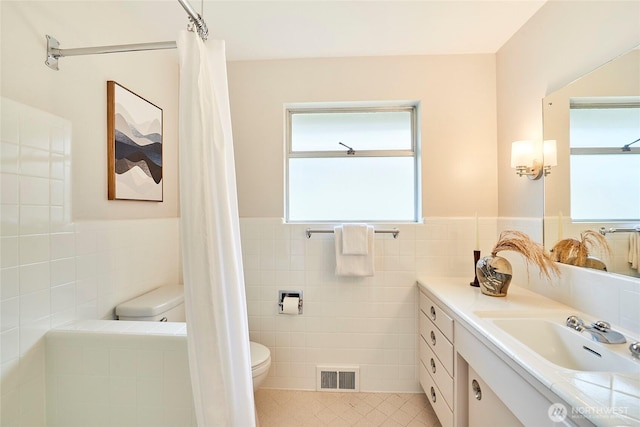 12747 9th Ave NW, Seattle, WA 98177 - bathroom featuring tile walls, toilet, wainscoting, plenty of natural light, and vanity