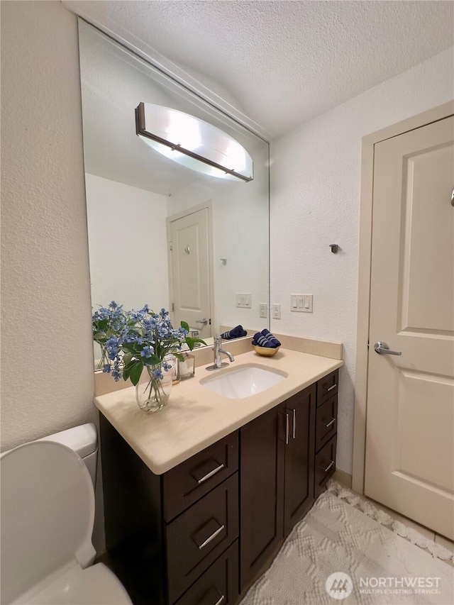 11054 NE 33rd Pl Unit B1, Bellevue, WA 98004 - bathroom with a textured ceiling, vanity, toilet, and a textured wall