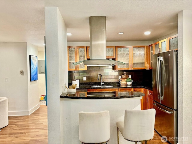 11054 NE 33rd Pl Unit B1, Bellevue, WA 98004 - kitchen featuring freestanding refrigerator, island range hood, a sink, tasteful backsplash, and baseboards