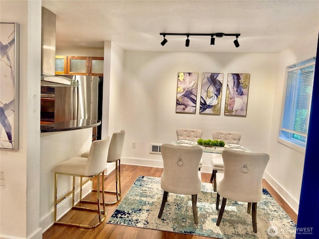 11054 NE 33rd Pl Unit B1, Bellevue, WA 98004 - dining room featuring wood finished floors, track lighting, and healthy amount of natural light