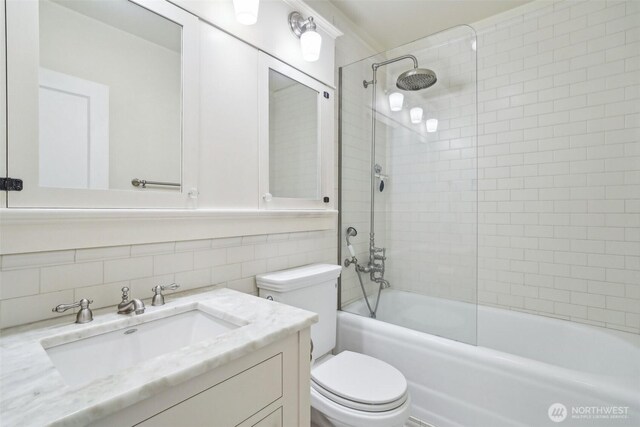 full bathroom featuring toilet, shower / bath combination, vanity, and tile walls