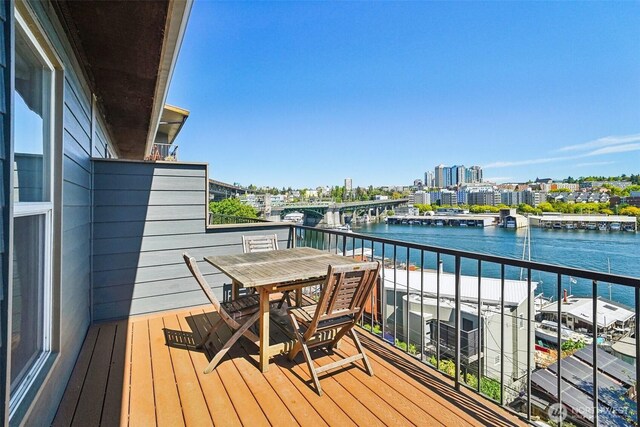 balcony with a water view and a view of city