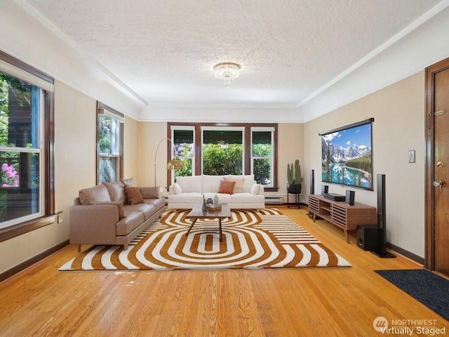 living room featuring a textured ceiling, light wood-style flooring, crown molding, baseboards, and a baseboard radiator